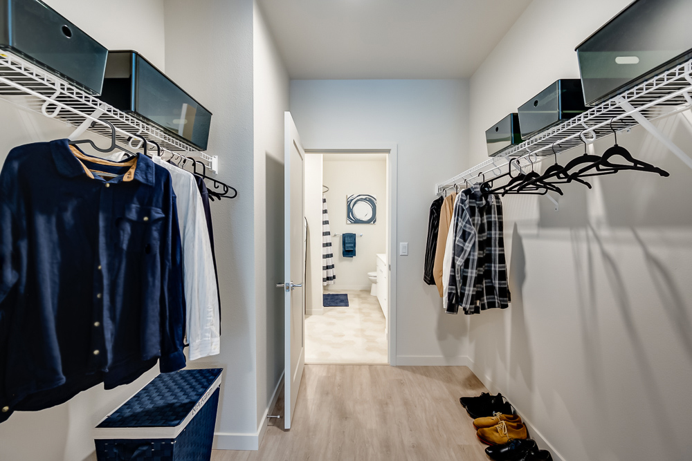 Spacious walk-in closet connected to the bathroom in an apartment at The Woods at Alderwood in Lynnwood, WA.