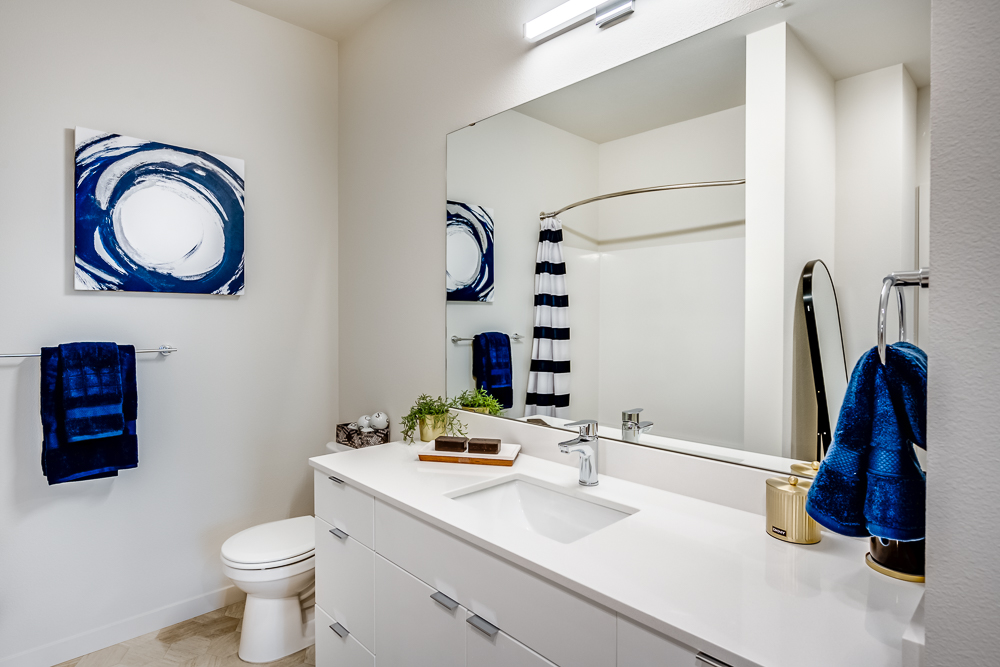 Bathroom with large mirror in an apartment at The Woods at Alderwood in Lynnwood, WA.