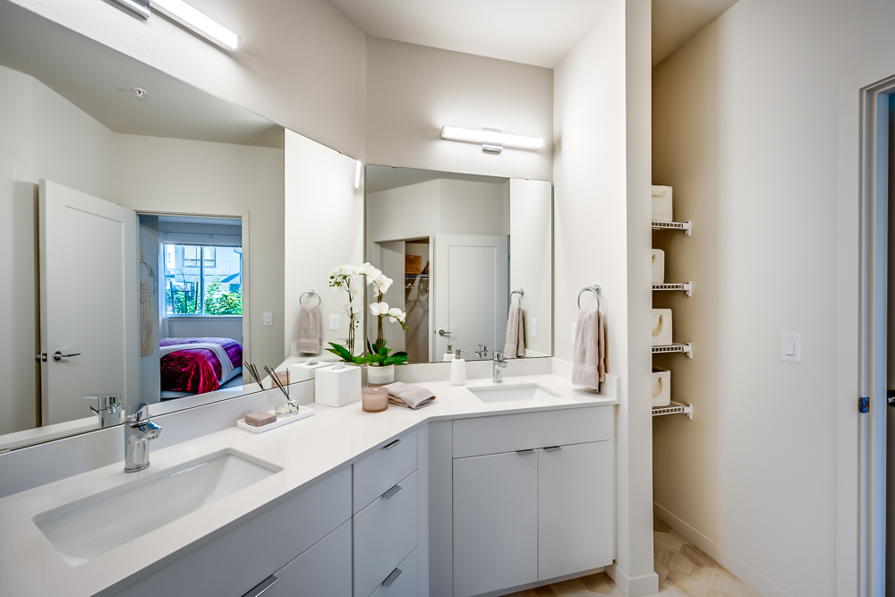 Bathroom with 2 sinks and large mirror in an apartment at The Woods at Alderwood in Lynnwood, WA.